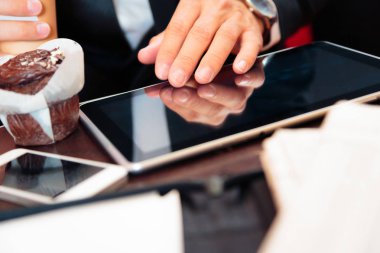 Onun Tablet üzerinde çalışan bir Cafe oturan işadamı