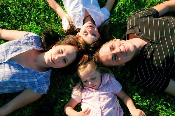 Famille couchée dans l'herbe — Photo