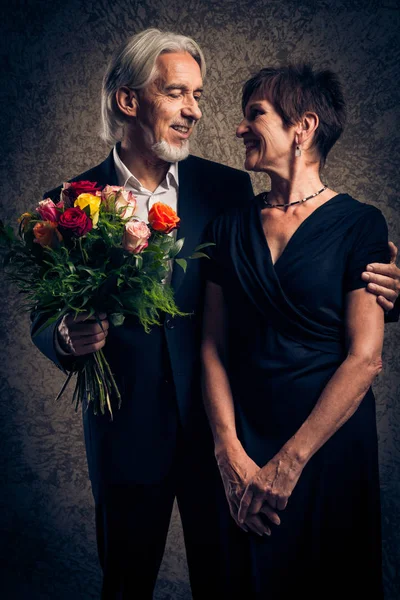 Casal casado sênior com buquê de rosas — Fotografia de Stock