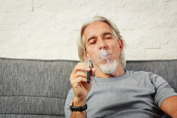 Vaping sênior, desfrutando de um cigarro eletrônico — Fotografia de Stock
