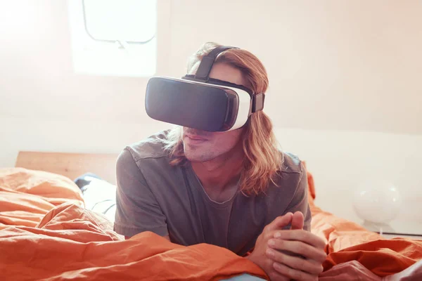 Young Man Lying On Bed With Vr Glasses