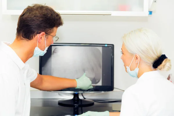 歯科医および歯科用 x 線をアシスタントに見て — ストック写真