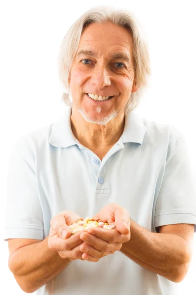 Happy Senior Man Taking a Whole Lot of Pills — стоковое фото