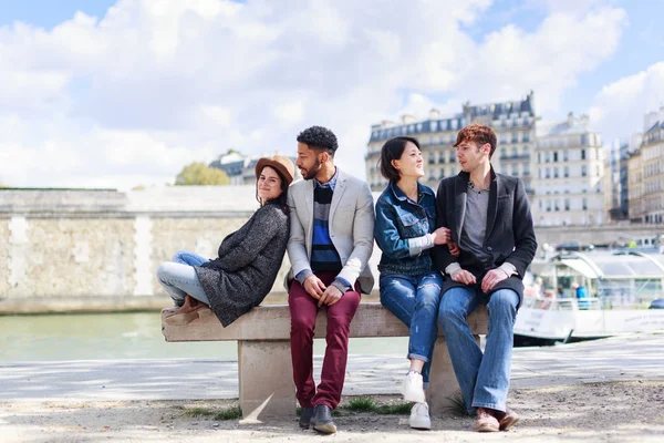 Многонациональная группа друзей, развлекающихся в Париже вдоль Сены — стоковое фото