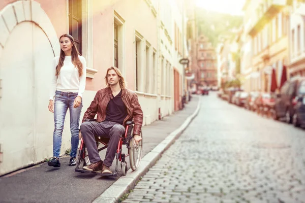 Νεαρό ζευγάρι στην αναπηρική καρέκλα μια βόλτα στην πόλη — Φωτογραφία Αρχείου