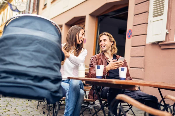 Young Parents With Baby Stroller Having Coffee At A Cafe — Stock Photo, Image