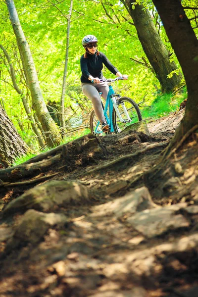 Mujer joven montando su bicicleta de montaña — Foto de Stock