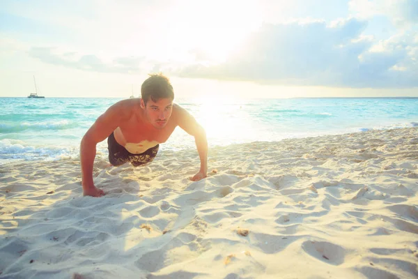 Hombre haciendo flexiones en la playa — Foto de Stock