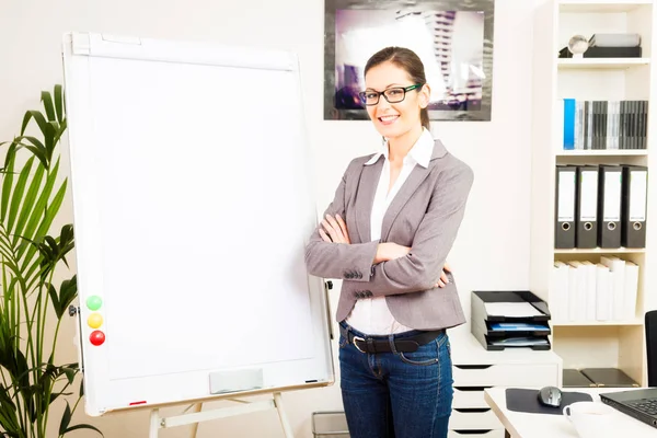 Empresária de pé ao lado de um flipchart vazio — Fotografia de Stock