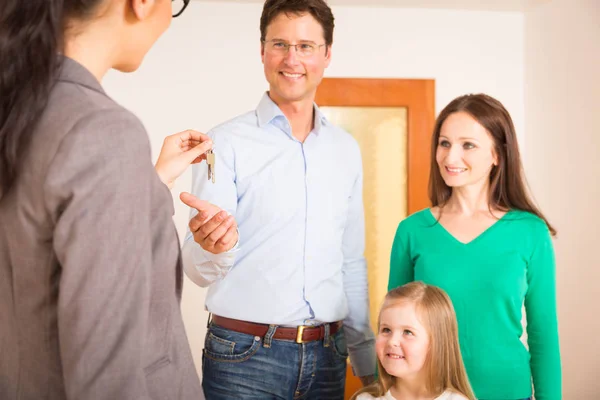 Realtor dando aos clientes a chave para seu novo plano — Fotografia de Stock