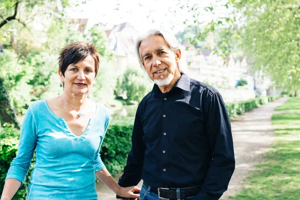 Casal Sênior Caminhando através de um parque — Fotografia de Stock