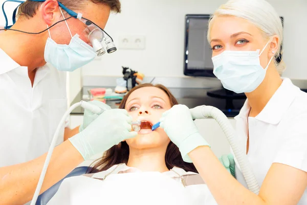 Mujer joven recibiendo un tratamiento en el dentista — Foto de Stock