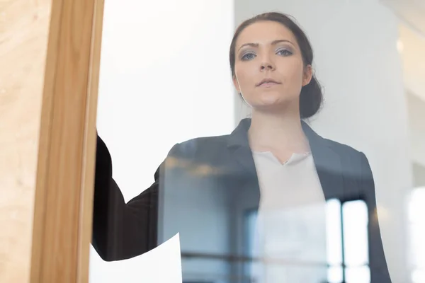 Mujer de negocios mirando por la ventana — Foto de Stock