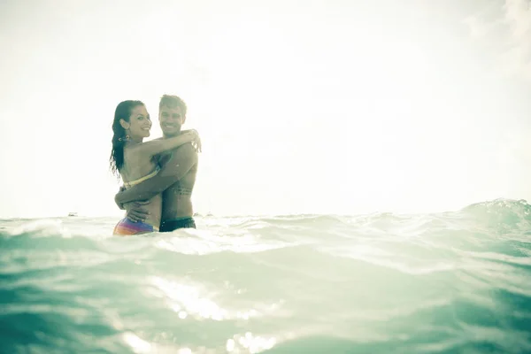 Pareja joven divirtiéndose en el mar — Foto de Stock