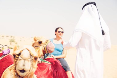 Arap adam ve turistik bir deve sürme
