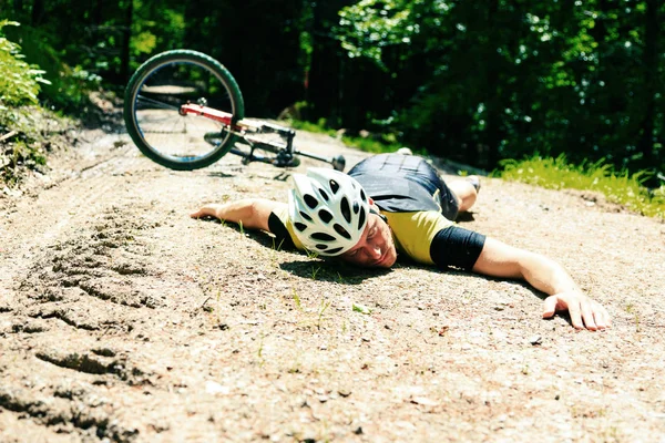 Велогонщик упал с велосипеда — стоковое фото