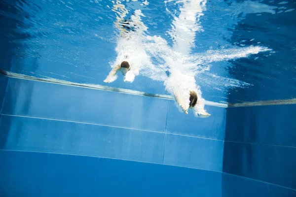 Vista subacquea di una giovane coppia che salta in acqua — Foto Stock