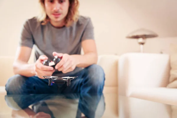 Giovane uomo giocare con un piccolo drone quadrocopter — Foto Stock