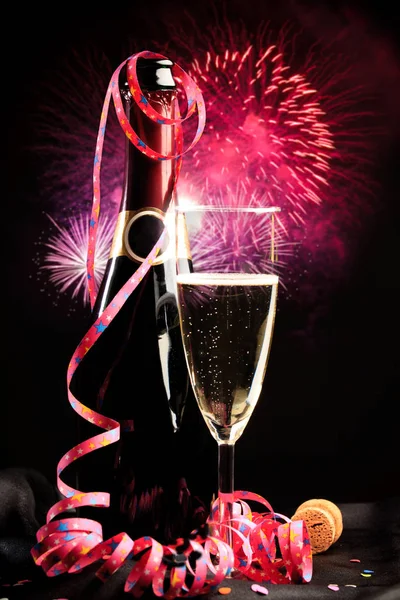 Láhev šampaňského s ohňostrojem na pozadí — Stock fotografie