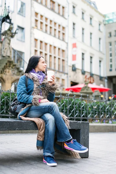 Genç bayan bir fincan kahve içiyor.