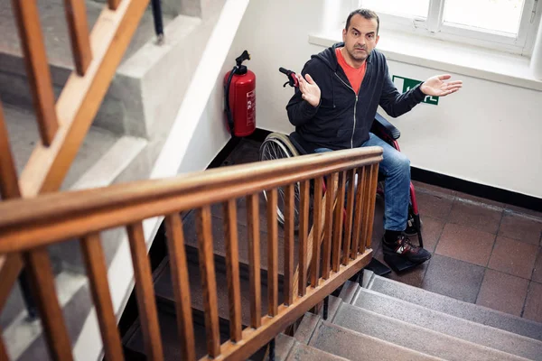 Człowiek na wózku inwalidzkim, zatrzymany na schodach — Zdjęcie stockowe