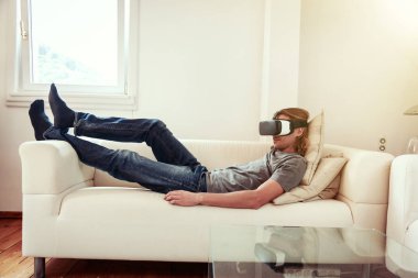 Kanepede oturan, Vr gözlükle genç adam