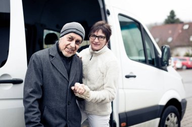 Nurse Helping Senior Man Enter A Van clipart