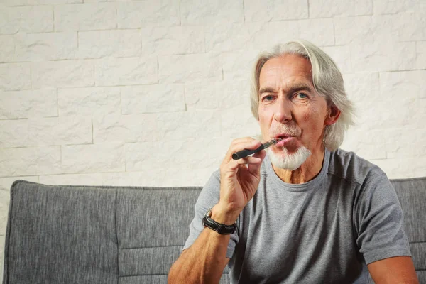 Vaping sênior, desfrutando de um cigarro eletrônico — Fotografia de Stock