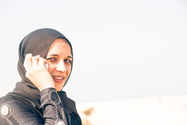 Sahilde oturan genç Arap kadın