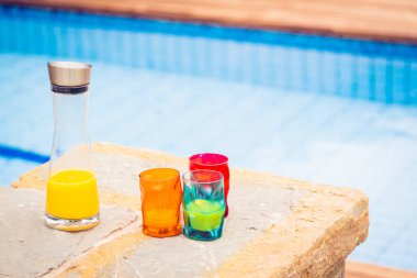 Renkli camlar ve havuzun yanında portakal suyu