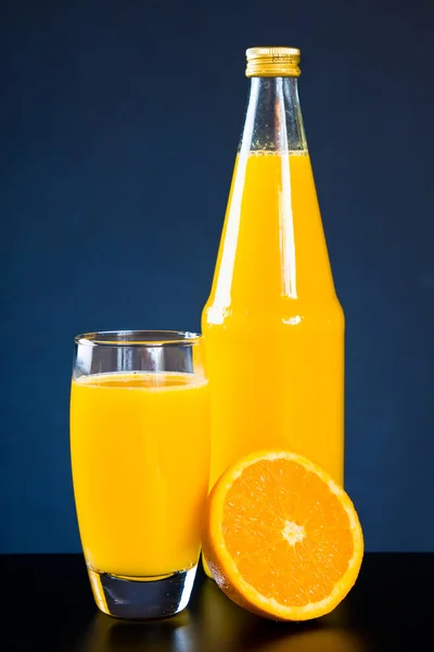 Bicchiere di succo con bottiglia e arancia — Foto Stock