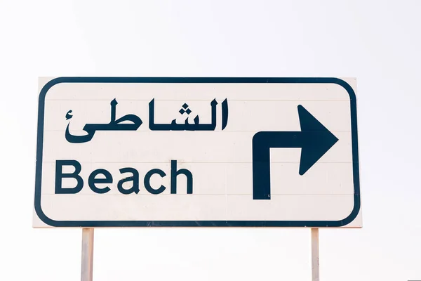 Strandschild mit lateinischen und arabischen Buchstaben — Stockfoto