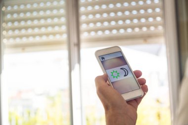 Akıllı ev: Adam telefonunu güneşlikler denetleme