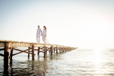 Genç çift iskelede yürüyor.