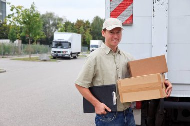 Bir kamyonun yanında duran servis elemanı