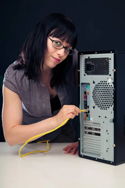 Young Woman Connecting A Network Cable