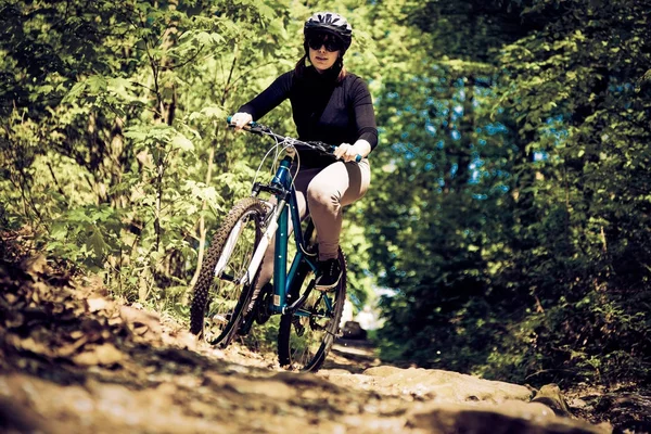 Ung kvinna rider hennes mountainbike — Stockfoto