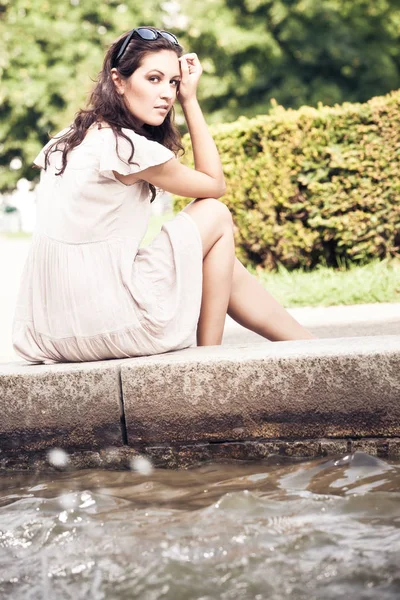 Bir çeşmenin oturan genç kadın