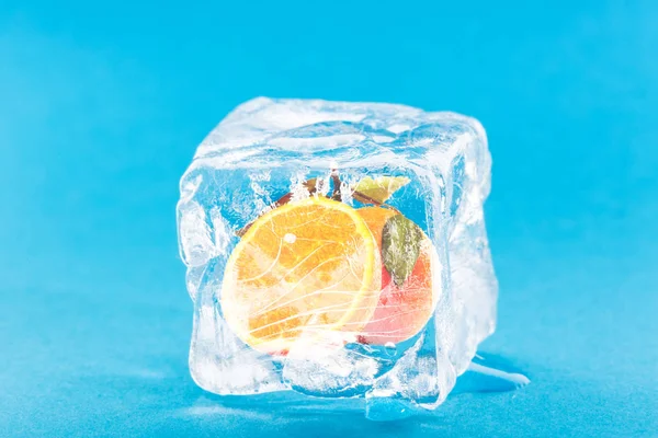 Замороженный апельсин внутри кубика льда — стоковое фото