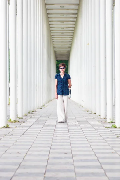 Senior Woman In White Pillar Hallway — Stock Photo, Image