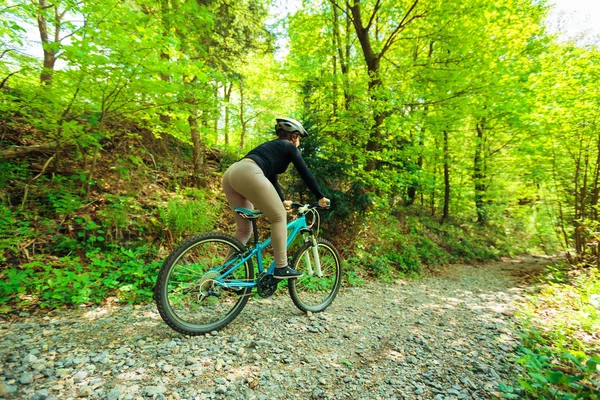 Mujer joven montando su bicicleta de montaña — Foto de Stock