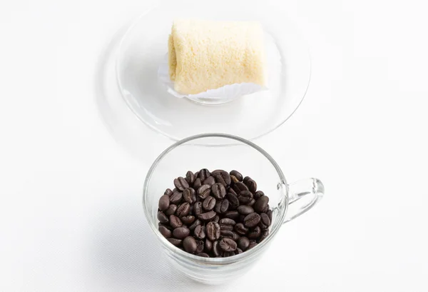 Granos de café oscuro con pastel de rollo suave . — Foto de Stock