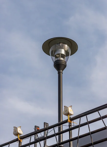 Modern lantern pole with the small lamp. — Stock Photo, Image