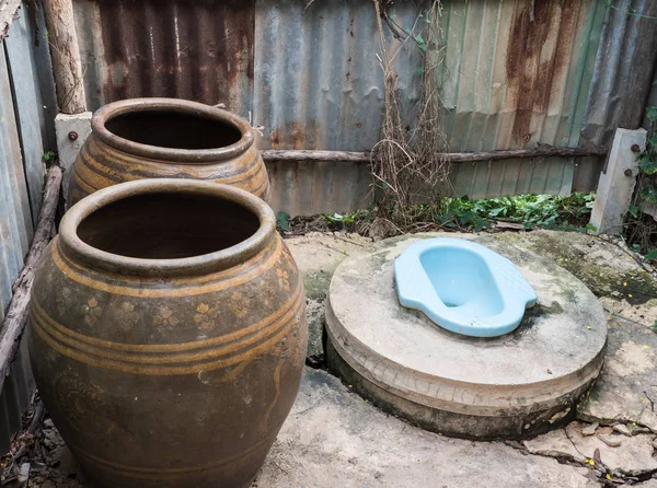 Büyük kavanoz ile kirli eski tuvalet.