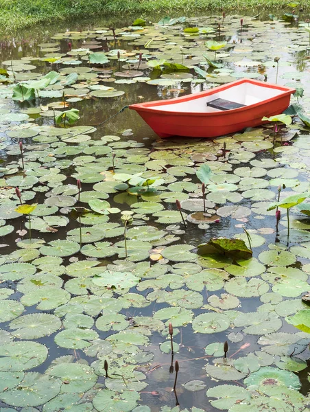 Red plastic boat in the small pond. — Stock Photo, Image