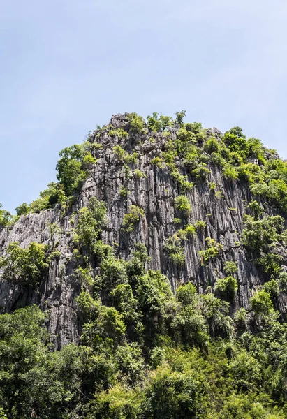 Alta montaña de piedra caliza con pequeña cueva . —  Fotos de Stock