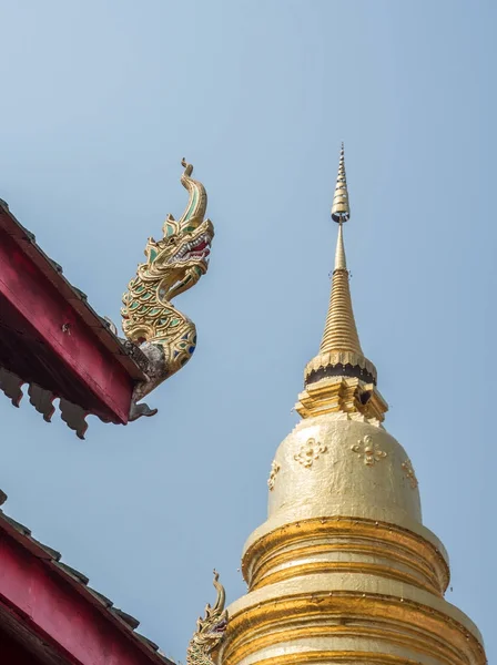 Dragon head carving in front of the golden pagada. — Stock Photo, Image