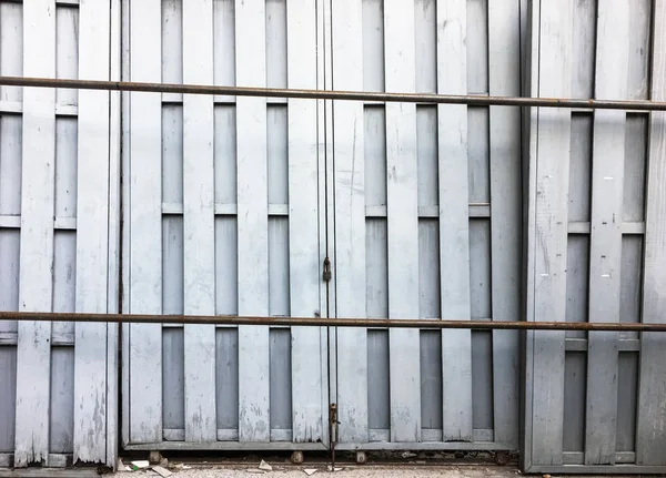 Oude houten deur die vergrendeld op de metalen rail. — Stockfoto