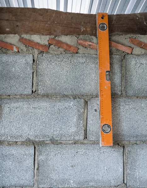 Old level ruler is hanging on the brick wall. — Stock Photo, Image