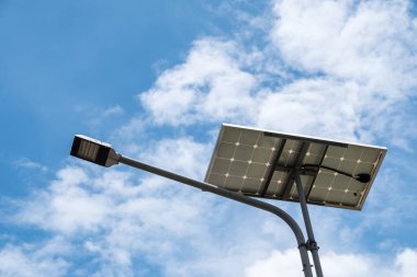 Sokak lambası, şehir parkındaki koruma sistemi için güneş paneli ile birlikte çalışıyor..